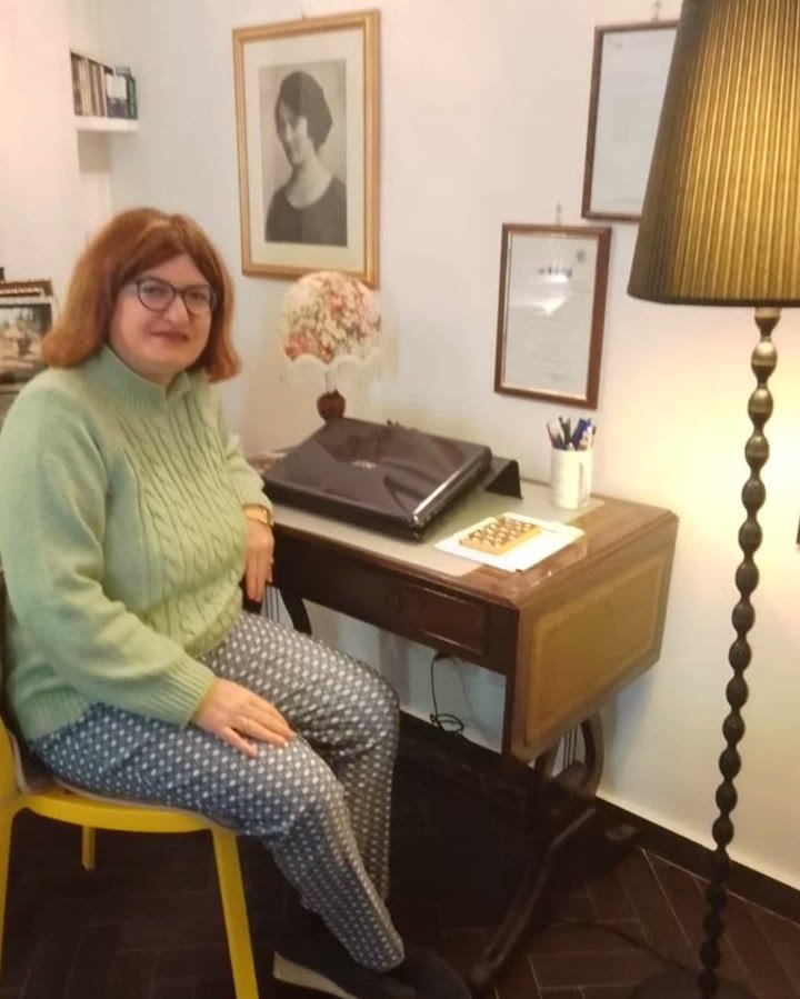 La Dottoressa Eleonora Quinti seduta alla scrivania del suo studio, con i diplomi alle pareti